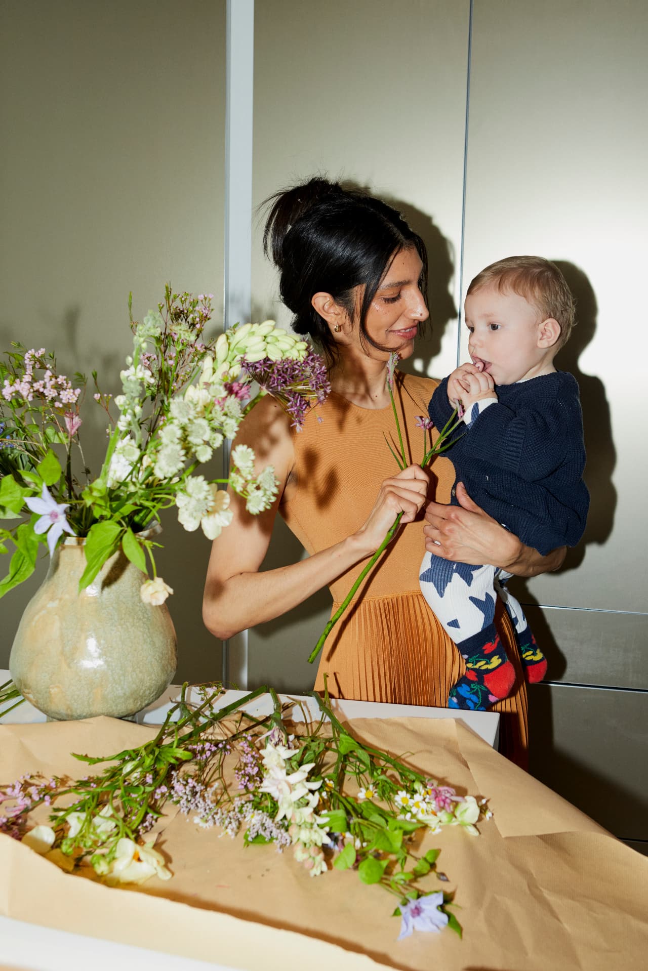 A florist arranging garden flowers on a brown-paper bench